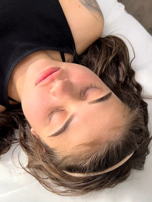 Client resting comfortably with softly healed ombré brows at Alter Ego Cosmetic Tattoo